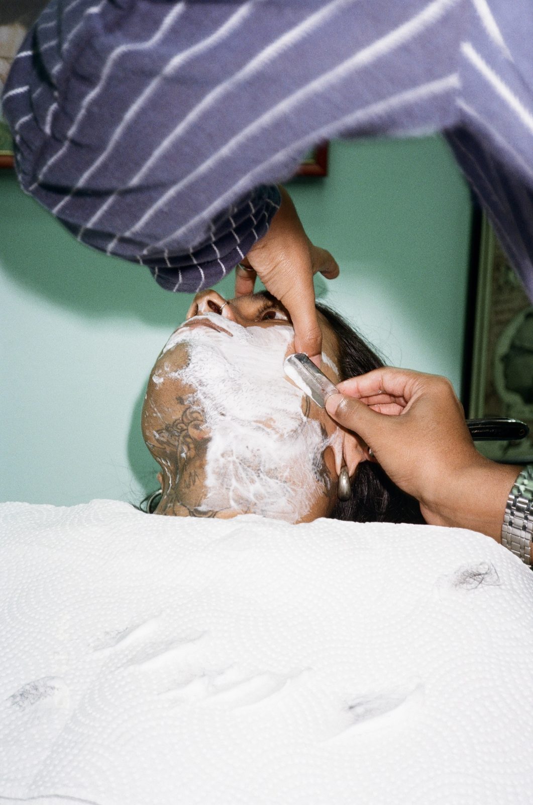 A hot towel shave in progress with a straight razor
